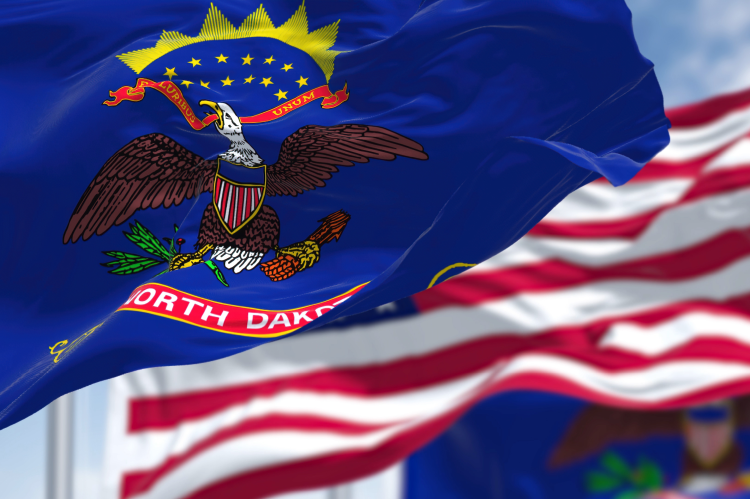 The flag of North Dakota with the US flag in the background (© Shutterstock/rarrarorro)