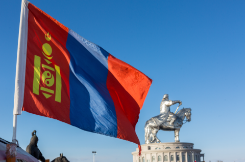 Flag of Mongolia infront of a statue of Genghis Khan (© Shutterstock/Pises Tungittipokai)