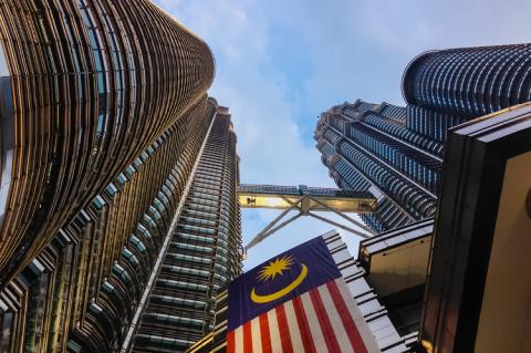 Petronas Towers with Malaysia national flag (© Shutterstock/sacitarios)