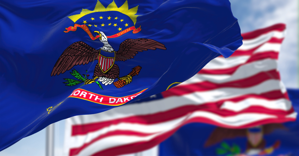 The flag of North Dakota with the US flag in the background (© Shutterstock/rarrarorro)